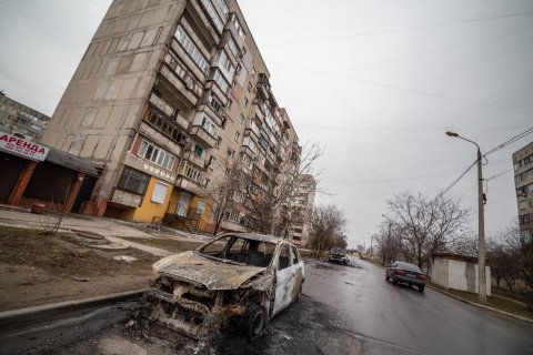 Ein Wohnblock und Autos nach der Explosion der Grad-Rakete.